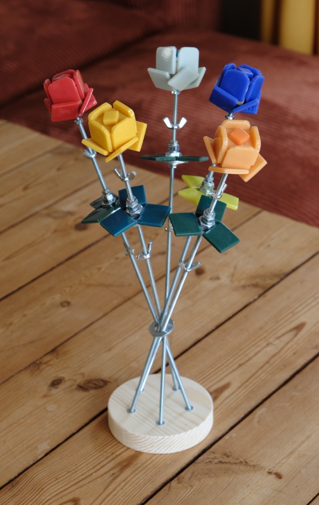 5 roses sur son support en bois